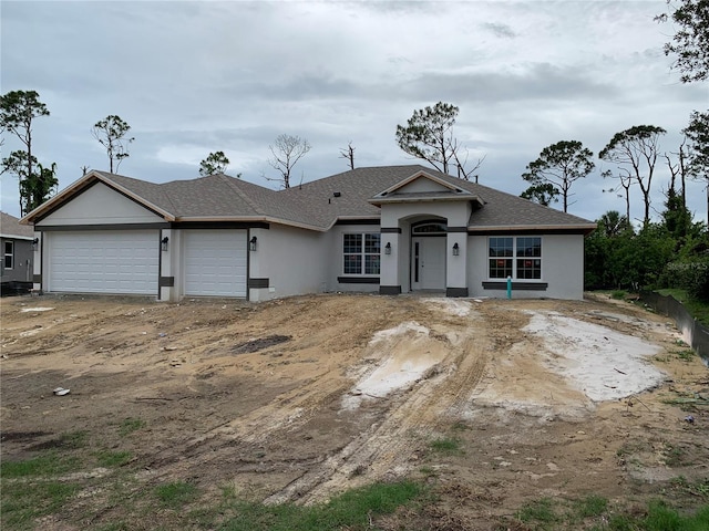47 Tee View Rd, Rotonda West, FL 33947 - view of front of property featuring a garage, stucco siding, and roof with shingles