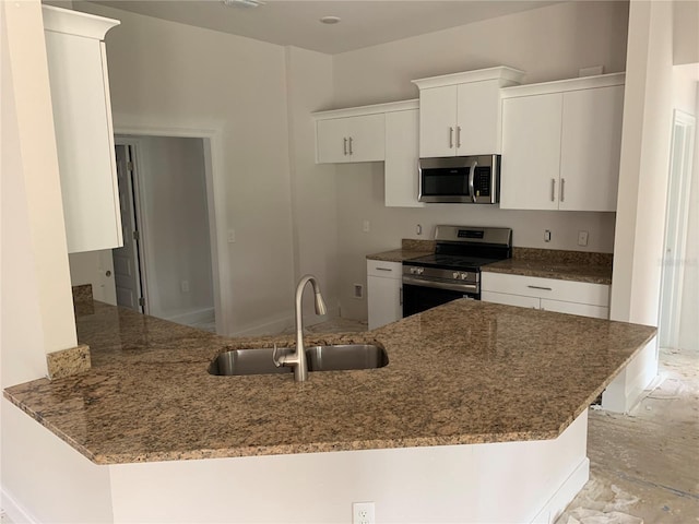 47 Tee View Rd, Rotonda West, FL 33947 - kitchen featuring stainless steel appliances, a peninsula, dark stone counters, and white cabinetry