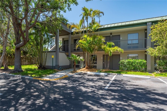 7150 N Tamiami Trl Unit S-600, Sarasota, FL 34243 - view of front of house featuring metal roof, stucco siding, and uncovered parking