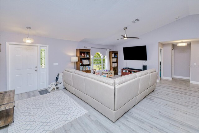 living area featuring light wood-style floors, lofted ceiling, a wealth of natural light, and baseboards