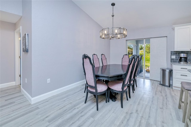 dining space featuring vaulted ceiling, an inviting chandelier, light wood-style flooring, and baseboards