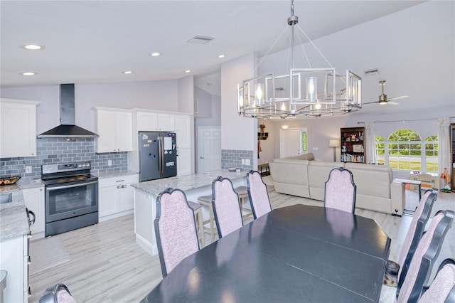 dining area featuring recessed lighting, visible vents, light wood-style floors, high vaulted ceiling, and ceiling fan with notable chandelier