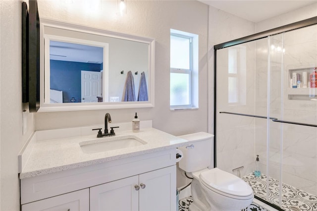full bathroom featuring a shower stall, toilet, and vanity