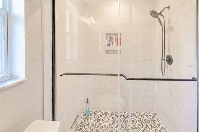 full bathroom with a shower stall, toilet, and a textured wall