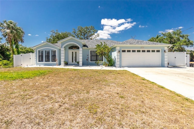 ranch-style home with a front lawn, a gate, french doors, a garage, and concrete driveway