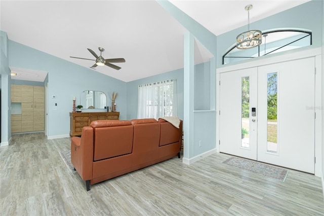 interior space featuring plenty of natural light, light wood-style flooring, baseboards, and vaulted ceiling