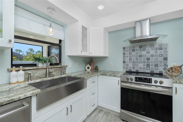 kitchen with light wood-type flooring, island range hood, light stone countertops, stainless steel appliances, and a sink