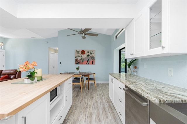 kitchen featuring butcher block countertops, glass insert cabinets, light wood-style flooring, ceiling fan, and dishwasher