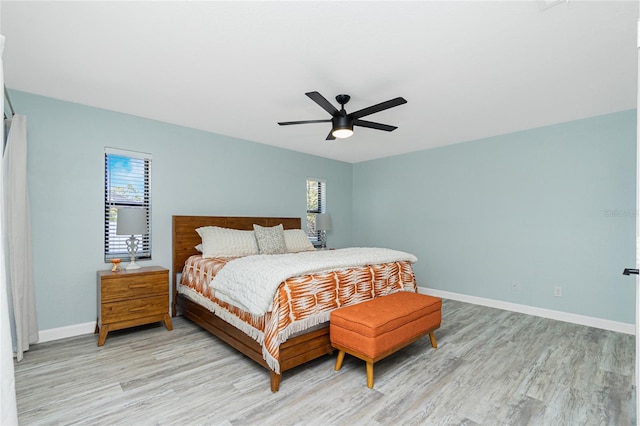 bedroom featuring light wood-type flooring, baseboards, and ceiling fan