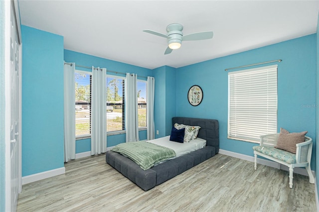 bedroom with ceiling fan, baseboards, and wood finished floors