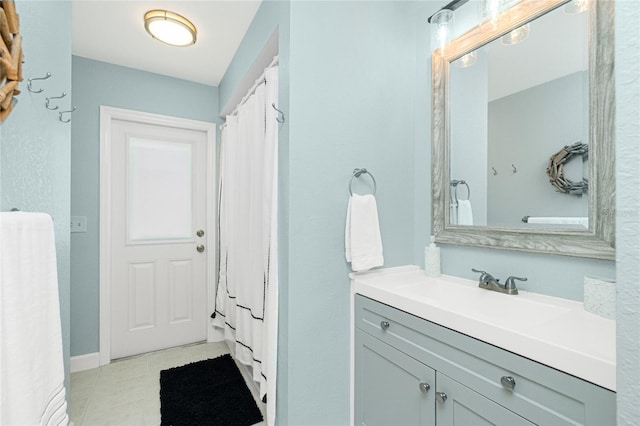 full bathroom featuring tile patterned floors and vanity