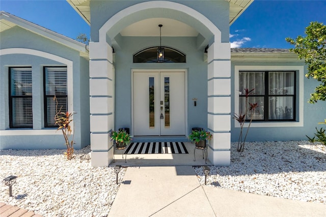 doorway to property featuring stucco siding and french doors