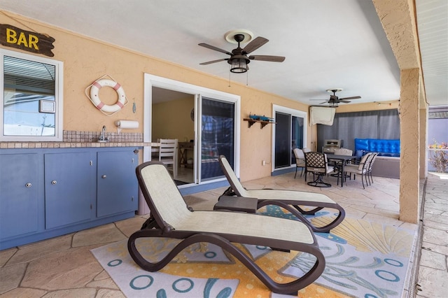 view of patio with a ceiling fan, outdoor dining space, and mail area