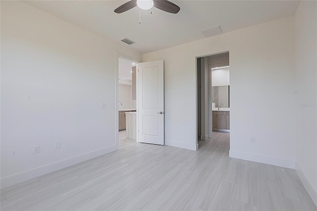 unfurnished bedroom featuring visible vents, light wood-style floors, and baseboards
