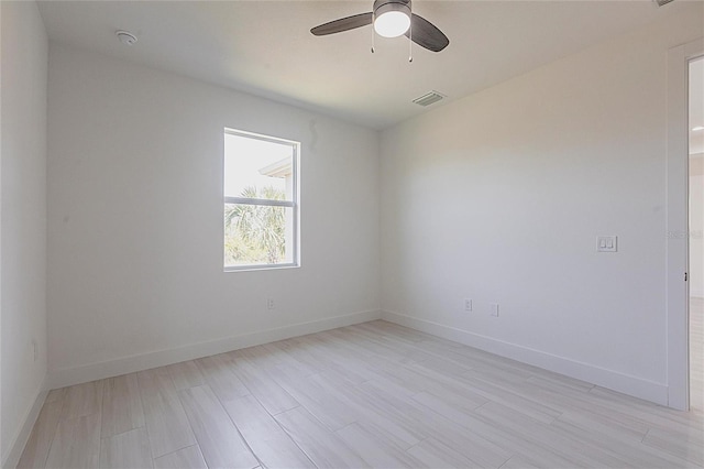 empty room featuring baseboards, ceiling fan, and light wood-style floors
