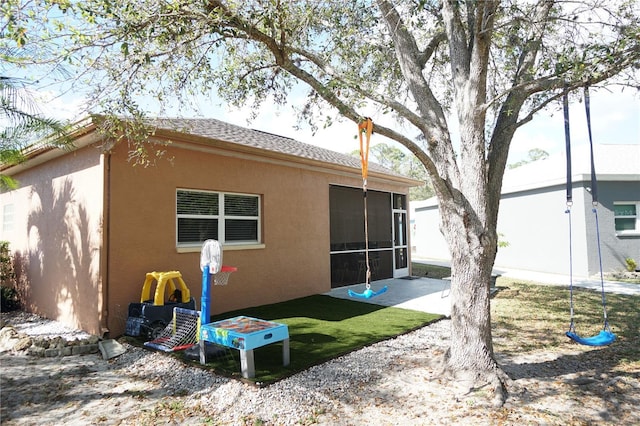10740 Pearl Bay Cir, Estero, FL 33928 - back of property with stucco siding, a patio, and a sunroom