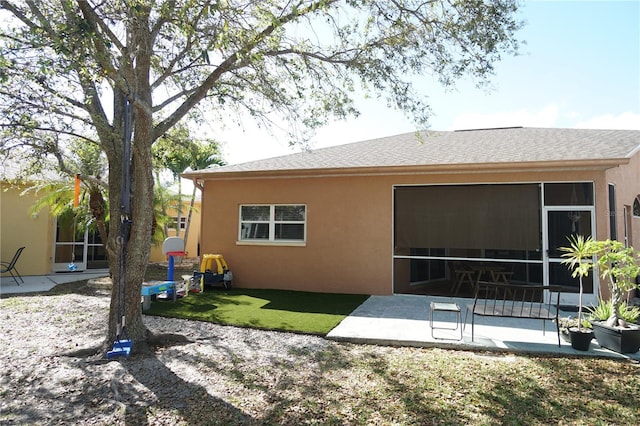 10740 Pearl Bay Cir, Estero, FL 33928 - rear view of property with stucco siding, a shingled roof, a patio, and a sunroom