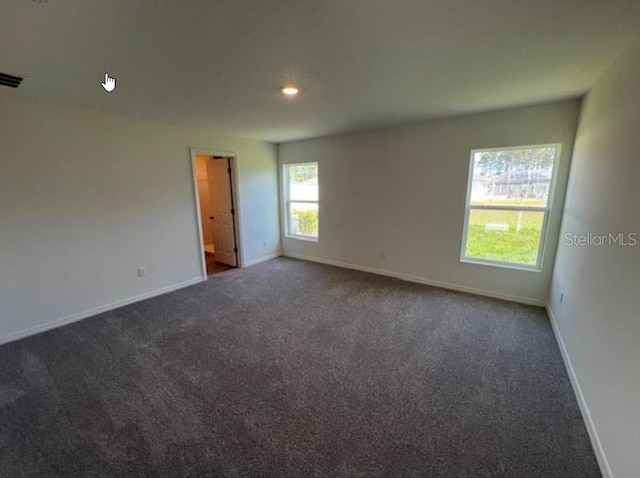 unfurnished room featuring baseboards, dark carpet, and recessed lighting