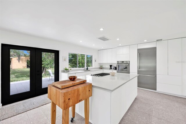 1635 SW Rodgers Ave, Arcadia, FL 34266 - kitchen with modern cabinets, appliances with stainless steel finishes, light tile patterned flooring, light countertops, and french doors