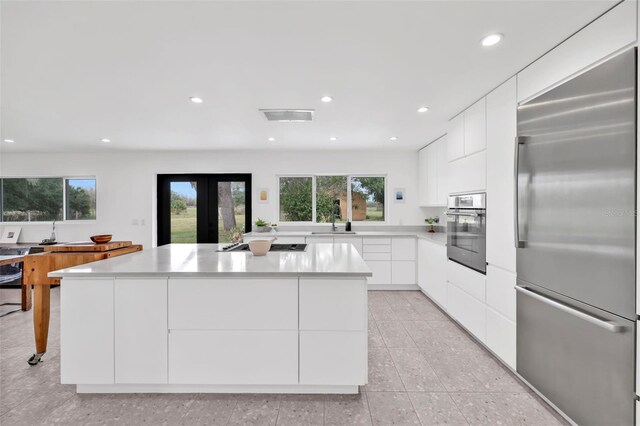 1635 SW Rodgers Ave, Arcadia, FL 34266 - kitchen with modern cabinets, light countertops, appliances with stainless steel finishes, white cabinetry, and a kitchen island