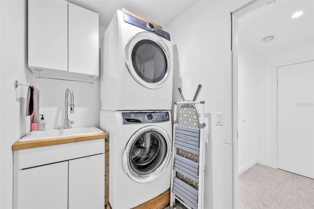 1635 SW Rodgers Ave, Arcadia, FL 34266 - laundry area featuring cabinet space, baseboards, stacked washer / drying machine, and a sink