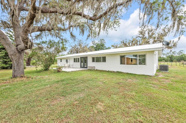 1635 SW Rodgers Ave, Arcadia, FL 34266 - back of property featuring central AC unit, a patio area, a yard, stucco siding, and french doors