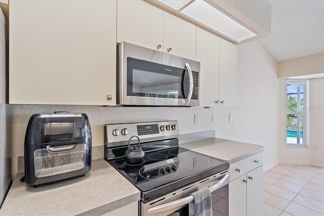 kitchen featuring white cabinetry, appliances with stainless steel finishes, and light countertops