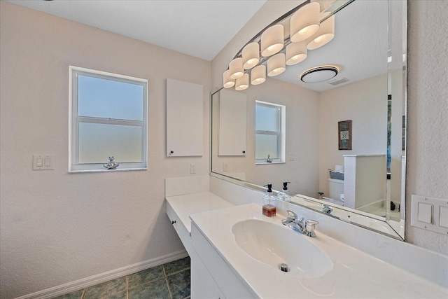 bathroom featuring toilet, visible vents, baseboards, and plenty of natural light