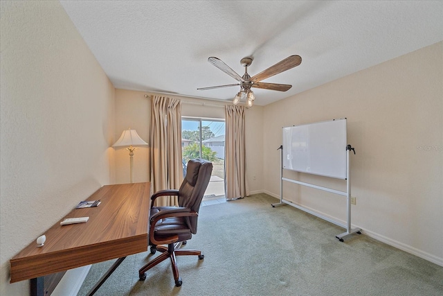 carpeted office with baseboards, a ceiling fan, and a textured ceiling