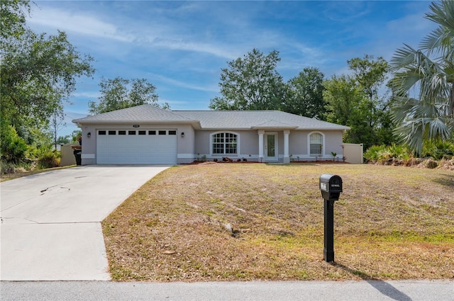 1773 Portage St, North Port, FL 34287 - single story home featuring stucco siding, an attached garage, driveway, and a front lawn