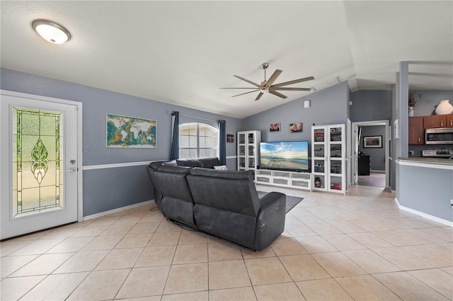 1773 Portage St, North Port, FL 34287 - living room featuring baseboards, ceiling fan, light tile patterned flooring, and vaulted ceiling