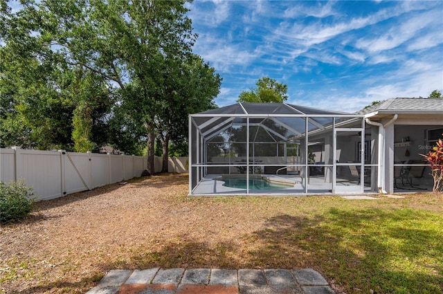 1773 Portage St, North Port, FL 34287 - view of yard featuring a fenced backyard, a patio, glass enclosure, and an outdoor pool