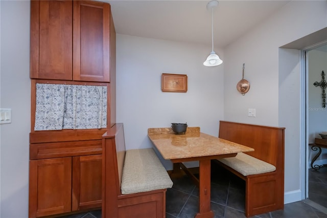 dining area with dark tile patterned floors and breakfast area