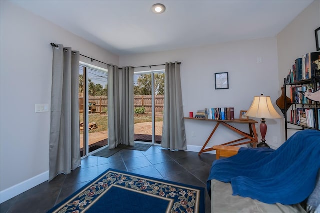 living area with baseboards and tile patterned floors