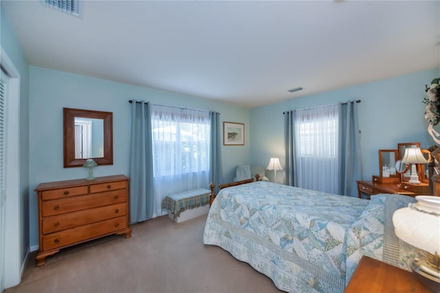 bedroom with multiple windows, visible vents, and carpet