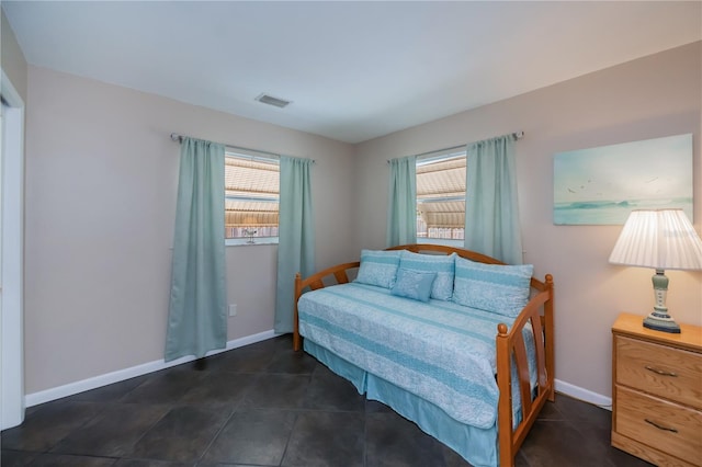 bedroom featuring visible vents, baseboards, and multiple windows