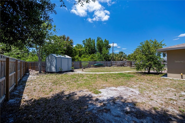 view of yard featuring a storage shed, a fenced backyard, and an outdoor structure