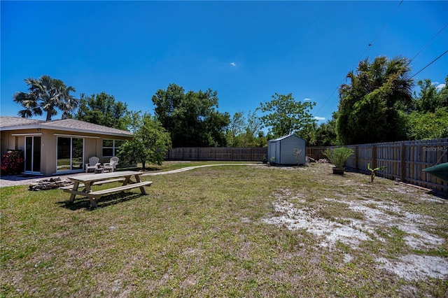 view of yard featuring a fenced backyard, a storage unit, and an outdoor structure