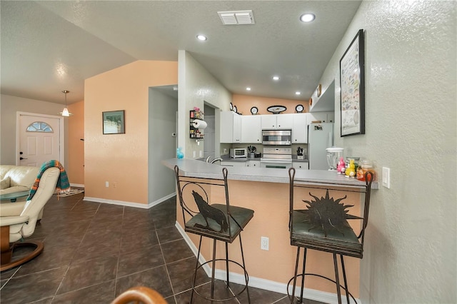 3175 Lakatos St, North Port, FL 34286 - kitchen featuring visible vents, vaulted ceiling, white appliances, and a breakfast bar area