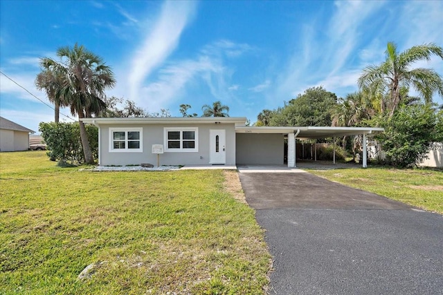 view of front of home featuring stucco siding, driveway, an attached carport, and a front yard