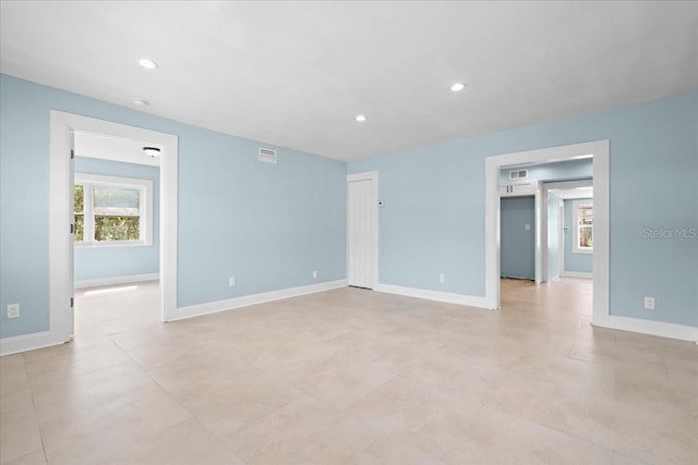 spare room featuring recessed lighting, visible vents, and baseboards