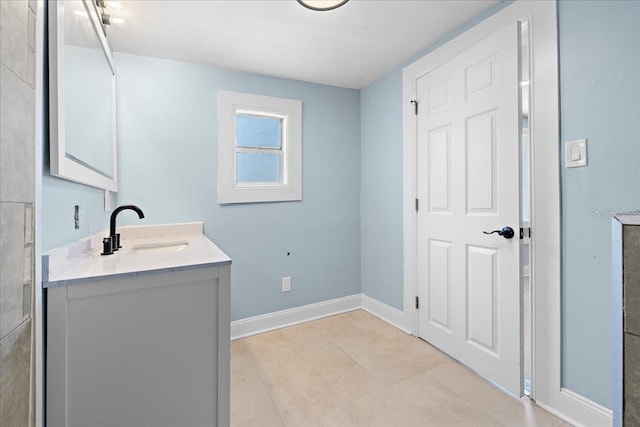 bathroom with tile patterned flooring, baseboards, and vanity