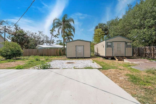 view of patio / terrace with a storage shed, an outbuilding, and fence