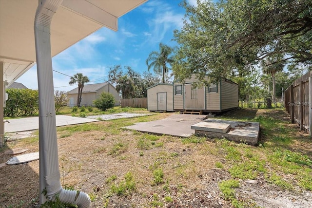 view of yard featuring a fenced backyard, an outbuilding, and a storage shed