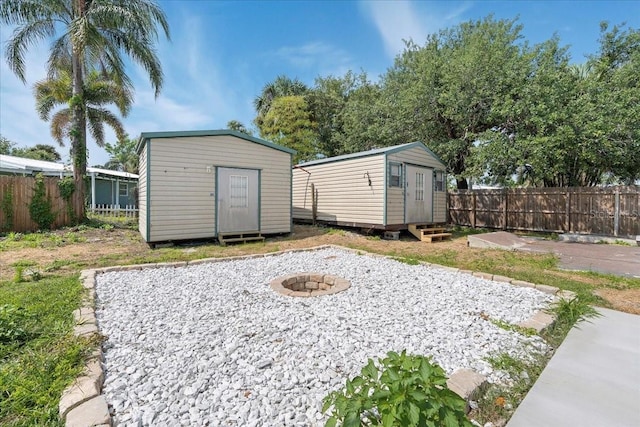 view of yard with a fire pit, fence, and a shed