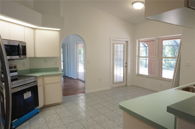 29211 Picador St, Punta Gorda, FL 33982 - kitchen featuring appliances with stainless steel finishes, arched walkways, baseboards, lofted ceiling, and light countertops