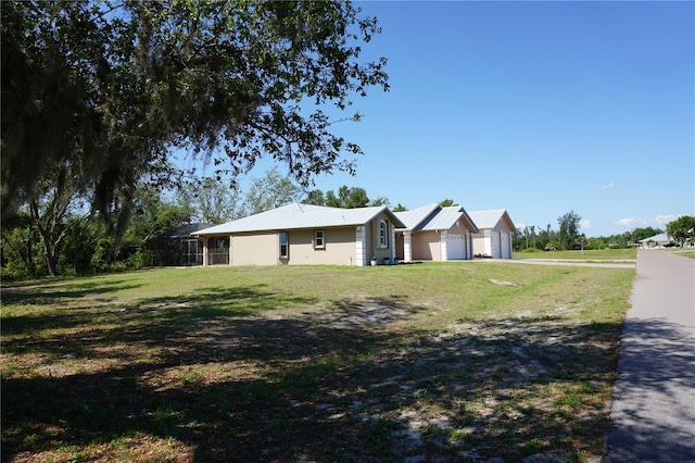 29211 Picador St, Punta Gorda, FL 33982 - view of front of home featuring a detached garage, a front yard, and metal roof