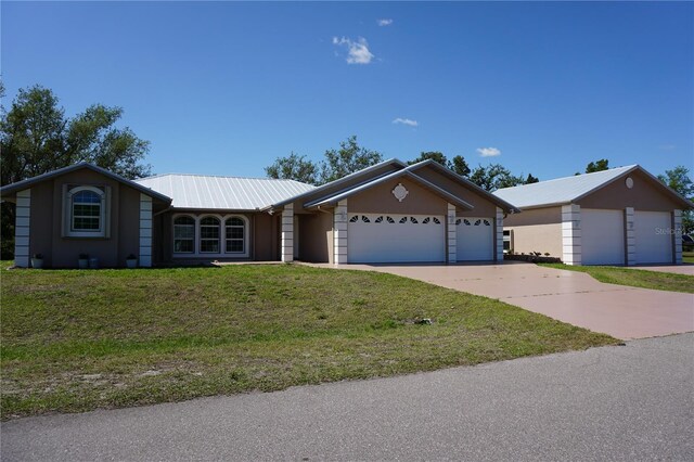29211 Picador St, Punta Gorda, FL 33982 - ranch-style home with metal roof, a front yard, an attached garage, and driveway