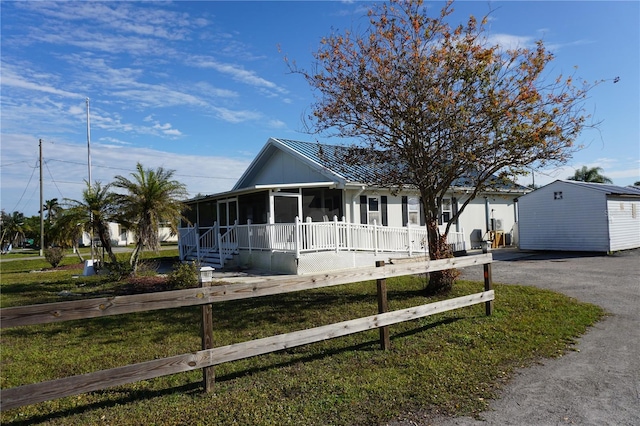 29211 Picador St, Punta Gorda, FL 33982 - view of front of property with a sunroom, a front yard, and asphalt driveway