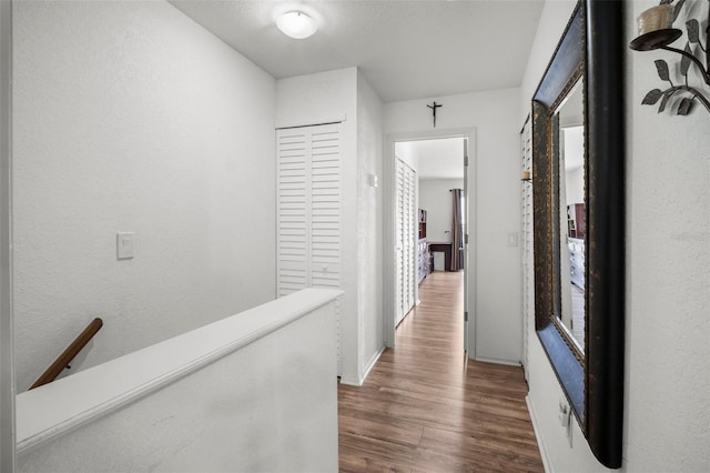 26290 Rampart Blvd Unit D, Punta Gorda, FL 33983 - hall with dark wood-type flooring, an upstairs landing, and a textured wall